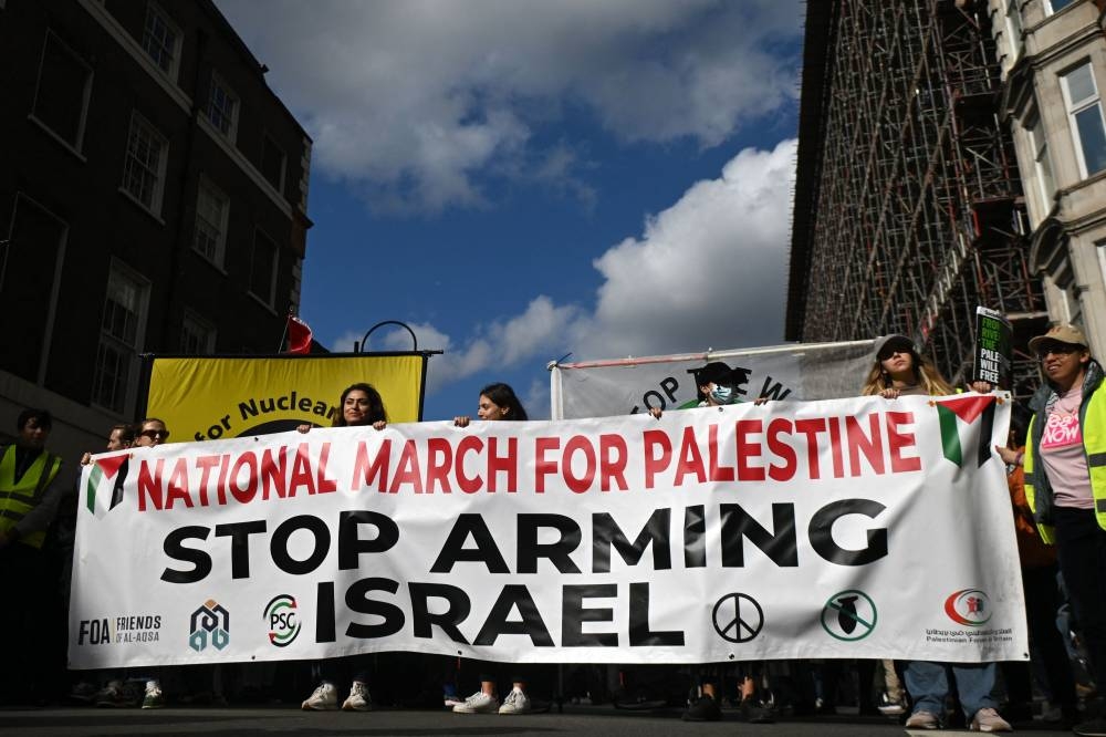 Pro-Palestinian activists and supporters wave flags and hold placards as they pass through central London, during a March for Palestine, on Saturday. AFP