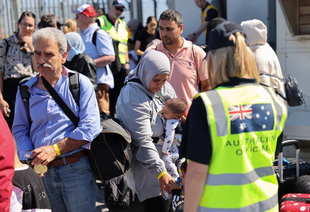 Australian officials stand by as Australian nationals, evacuated from Lebanon arrive at Larnaca International Airport, in Larnaca, Cyprus, on Saturday. REUTERS