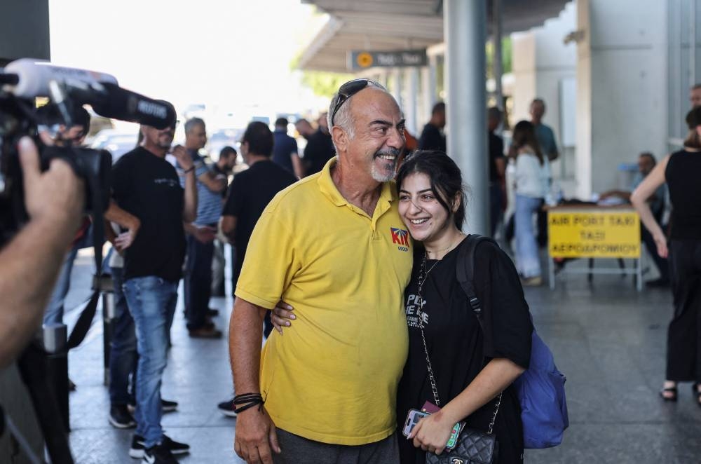 Clea Rita Barsamian embraces her father after being evacuated from Lebanon, at the Larnaca International Airport, in Larnaca, Cyprus on Thursday. REUTERS