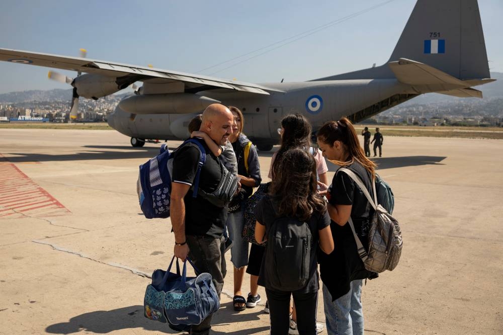 A family prepares to board a Hellenic Air Force C130 as Greek and Greek Cypriot nationals are evacuated from Lebanon, in Beirut, on Thursday. REUTERS
