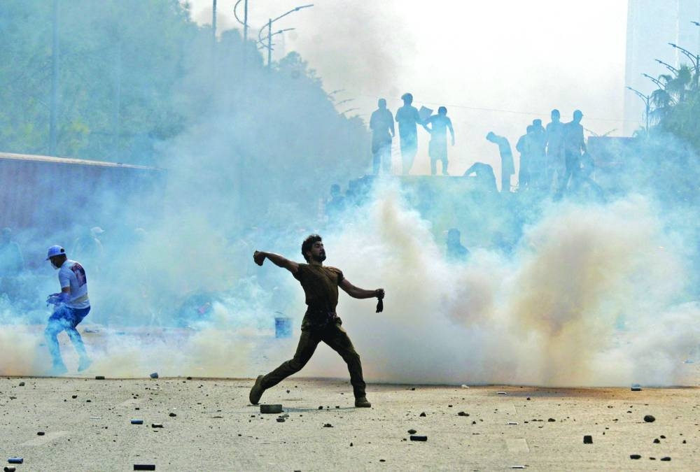 
A supporter of the PTI throws back a tear gas shell fired by police during an anti-government rally in Islamabad. – Reuters 