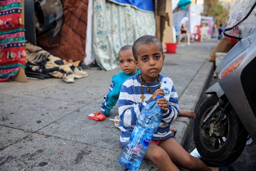 Displaced children from Ethiopia sit by makeshift shelters along a seaside in western Beirut, on Sunday. REUTERS