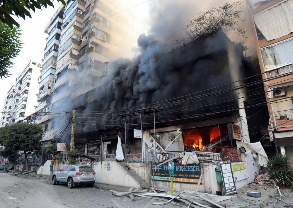 Smoke rises from shops, in the aftermath of Israeli strikes on Beirut's southern suburbs, on Sunday. REUTERS