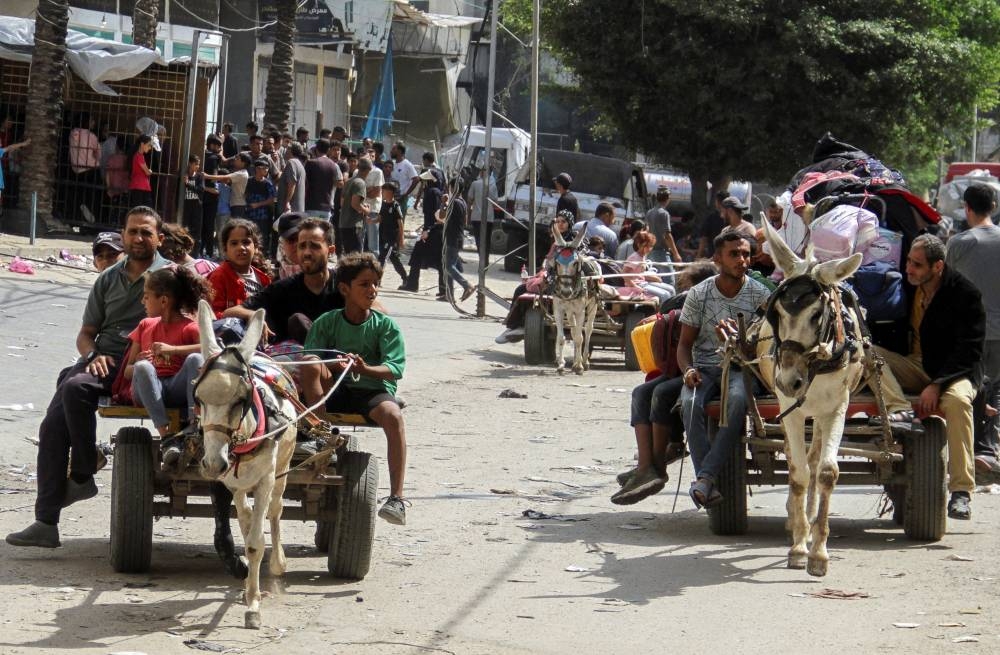 Displaced Palestinians travel in animal-drawn carts as they flee areas in the northern Gaza Strip, following an Israeli evacuation order in Gaza, on Sunday. REUTERS
