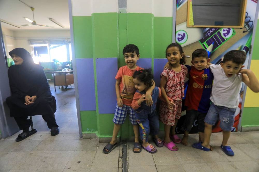 Children stand outside a classroom at a school, housing families displaced from the south of Lebanon, in Beirut on Saturday. AFP