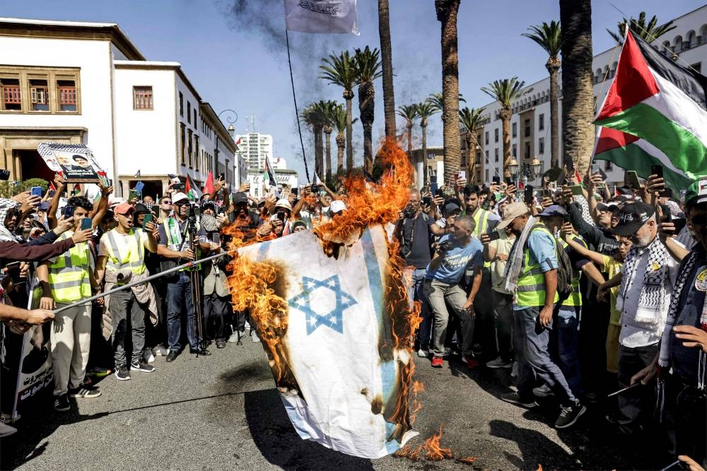 Protesters burn a makeshift Israeli flag during a rally in solidarity with Palestinians in Morocco's capital Rabat, on Sunday. AFP