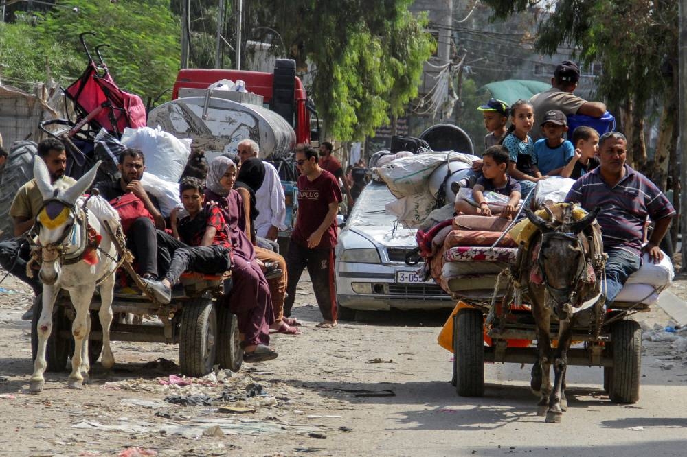 Displaced Palestinians travel in animal-drawn carts as they flee areas in the northern Gaza Strip, following an Israeli evacuation order,  in Gaza on Sunday. REUTERS