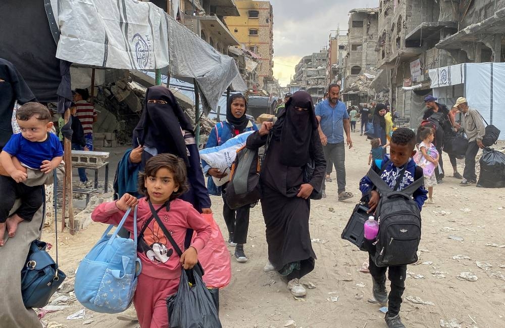 Displaced Palestinians make their way as they flee areas in northern Gaza Strip following an Israeli evacuation order, in Jabalia on Sunday. REUTERS