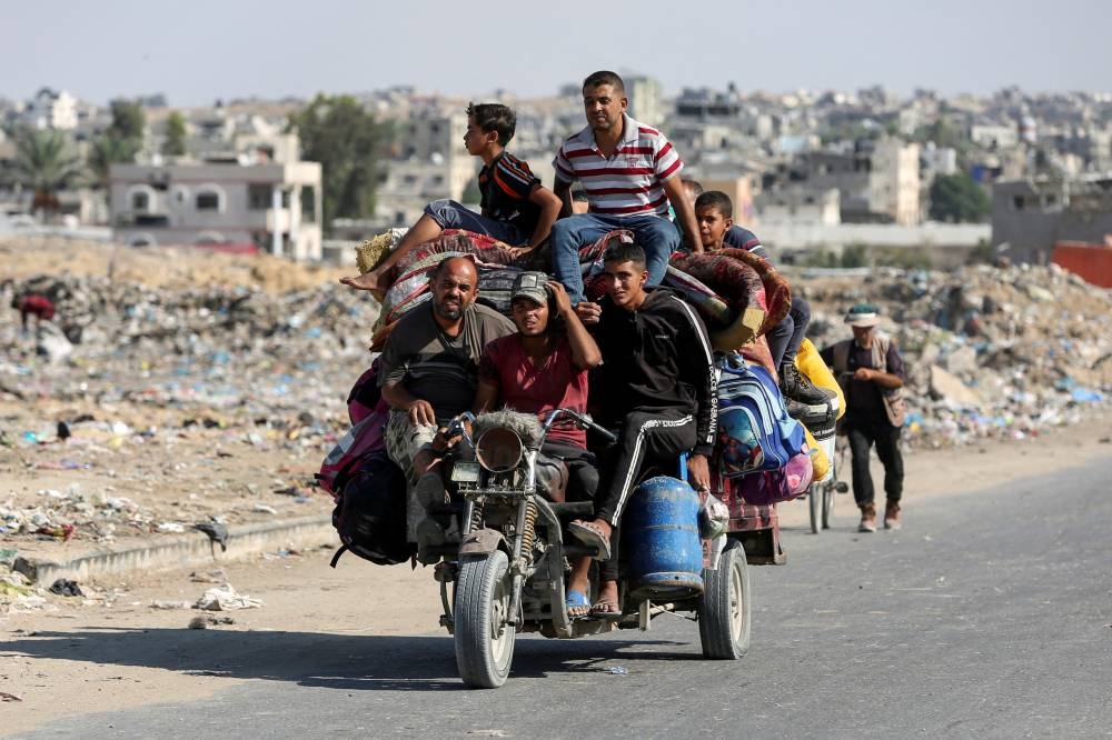 Displaced Palestinians make their way to flee areas in the eastern part of Khan Younis following an Israeli evacuation order, in Khan Younis in the southern Gaza Strip, on Monday. REUTERS