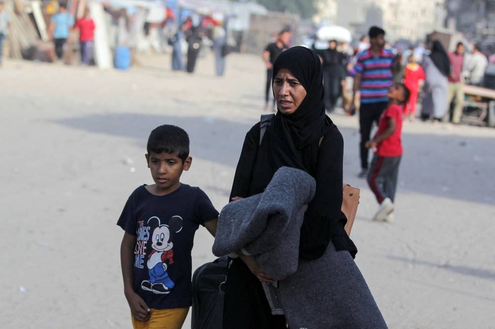 Displaced Palestinians make their way to flee areas in the eastern part of Khan Younis following an Israeli evacuation order, in Khan Younis in the southern Gaza Strip, on Monday. REUTERS