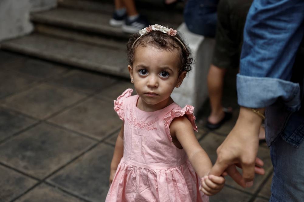 A displaced child  walks with her mother in a school which provides them temporary shelter, in Beirut, Lebanon, on Monday. REUTERS