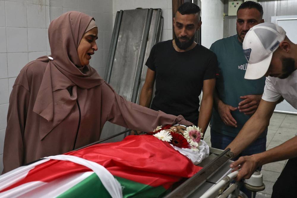 The mother of 12-year-old Palestinian Hatem Sami Ghaith, who died as a result of wounds sustained during an Israeli raid, mourns her son at the morgue in Ramallah in the Israeli occupied West Bank, on Monday. AFP