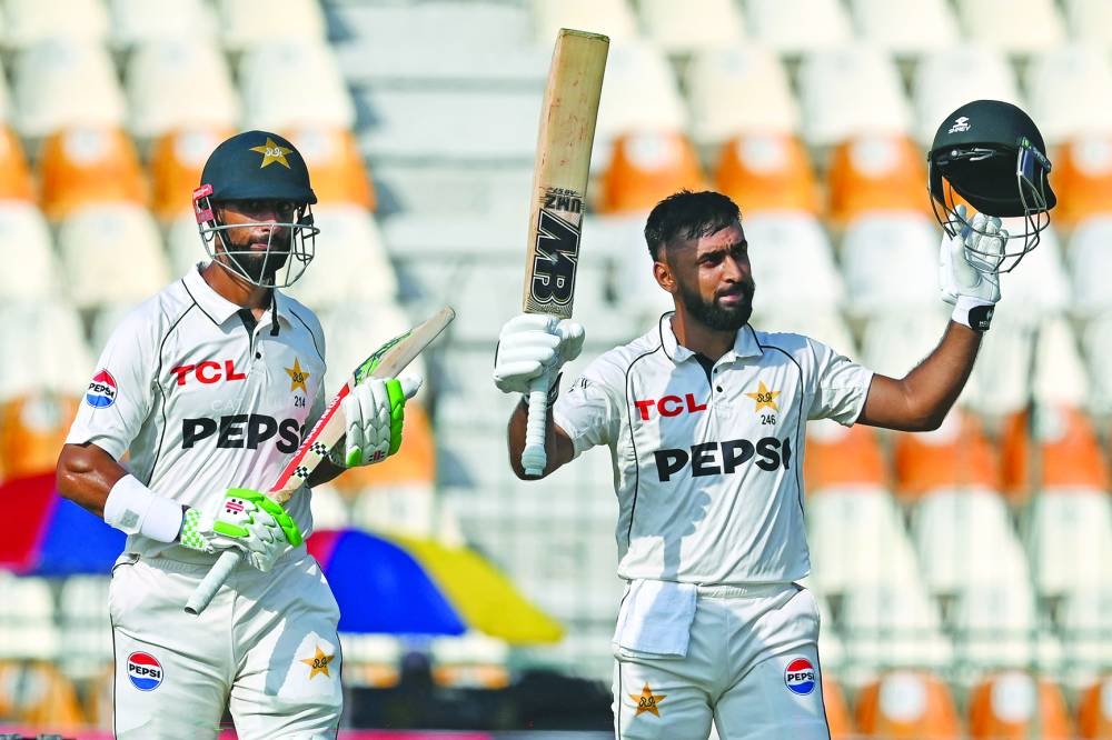 Pakistan’s Abdullah Shafique (right) celebrates after scoring a century as his captain Shan Masood watches during the first day of the first Test against England at the Multan Cricket Stadium on Monday. (AFP)