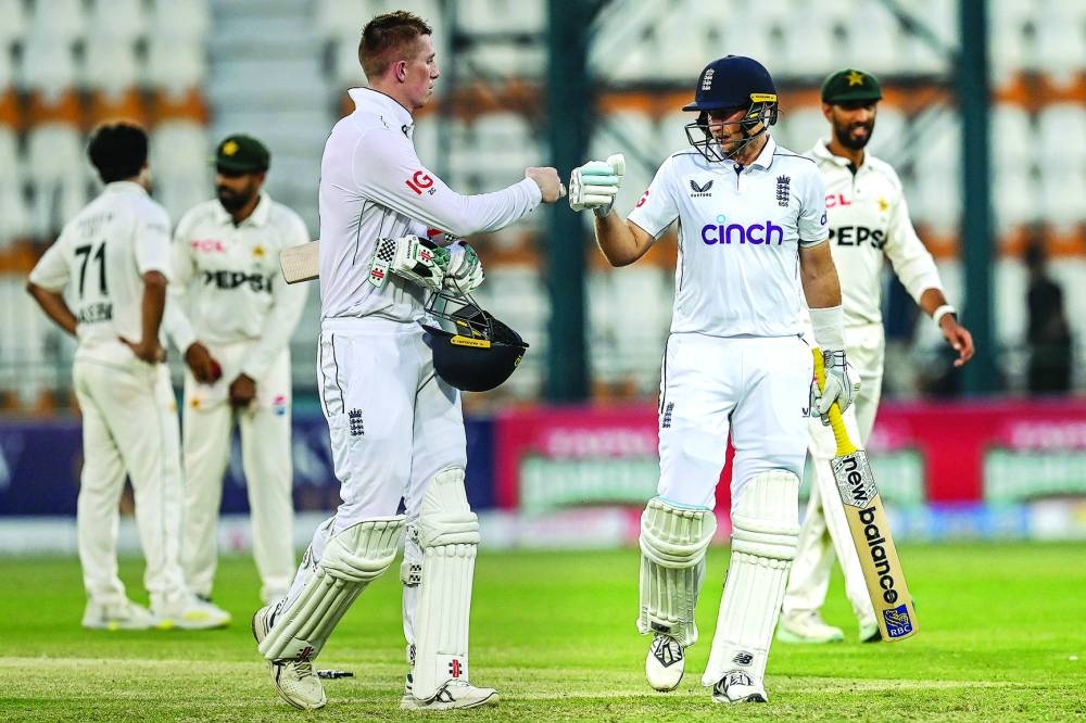 England’s Joe Root (right) and Zak Crawley bump their fists at the end of the second day of the first Test against Pakistan. (AFP)