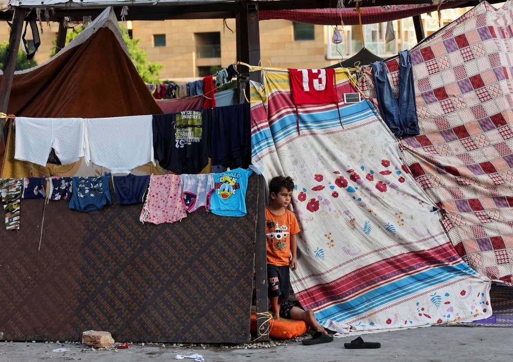 A displaced boy looks on at a makeshift encampment on the street at Beirut's central Martyrs' Square, where many families spend the night fleeing the overnight Israeli strikes in southern Beirut, in Lebanon, on Wednesday. , on Tuesday. REUTERS