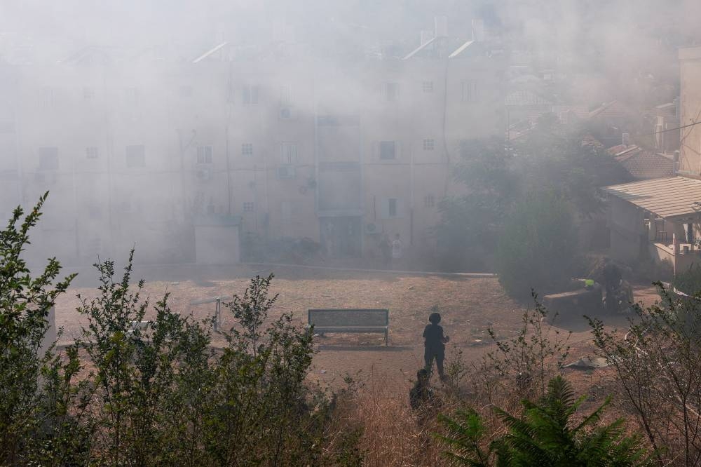 Emergency personnel work following a fire at a residential building caused by a rocket fired from Lebanon towards Israel, in Kiryat Shmona, northern Israel, on Wednesday. REUTERS
