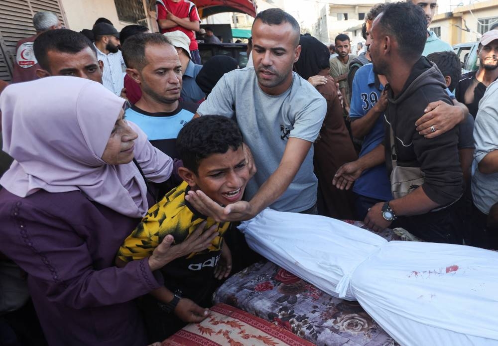 A boy mourns near the body of his father and other Palestinians, who were killed in an Israeli strike at Al-Aqsa Martyrs Hospital in Deir Al-Balah in the central Gaza Strip, on Wednesday. REUTERS