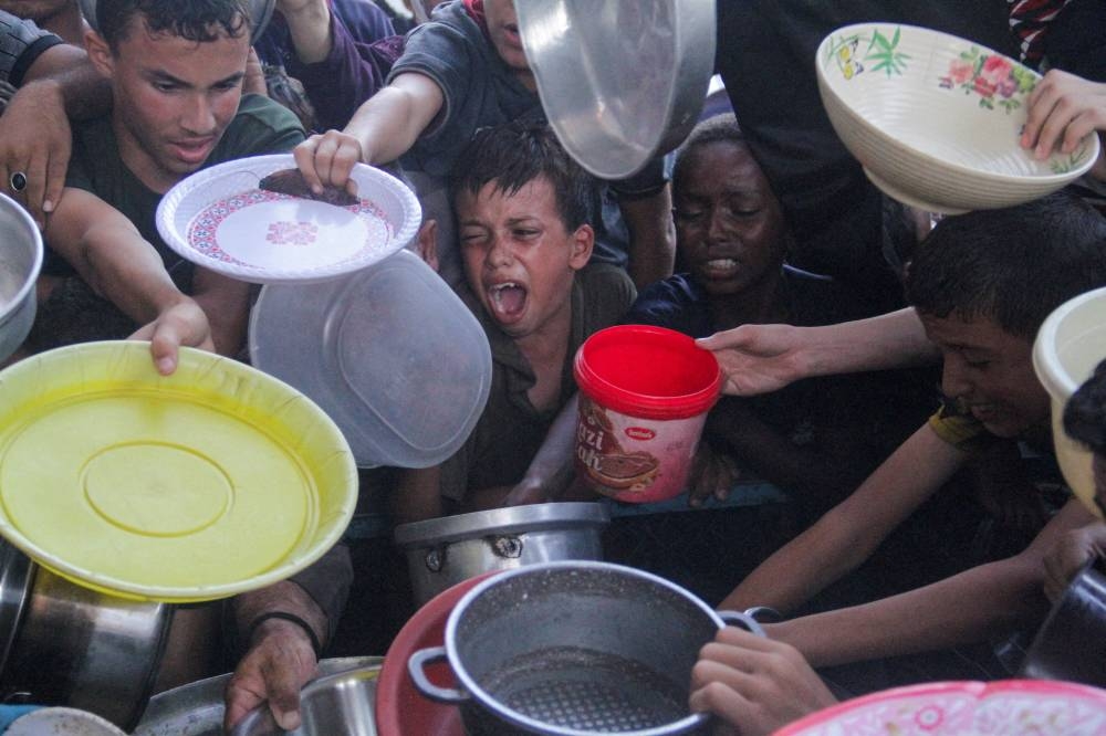 Palestinians gather to receive food cooked by a charity kitchen, in the northern Gaza Strip, on September 11, 2024. File photo: REUTERS