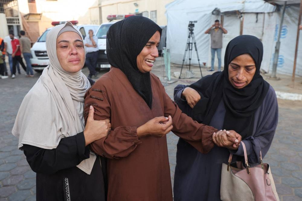 Mourners react near the bodies of Palestinians, who were killed in an Israeli strike at Al-Aqsa Martyrs Hospital in Deir Al-Balah in the central Gaza Strip, on Wednesday. REUTERS