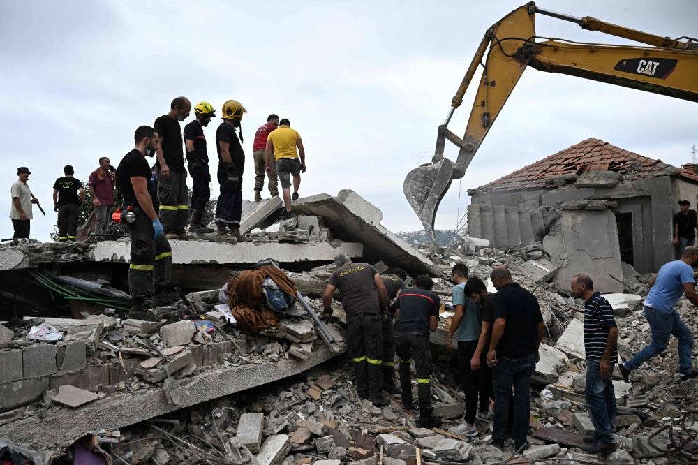 Lebanese civil defence workers clear debris at the site of an Israeli airstrike on the Mount Lebanon village of Maaysra, east of the coastal town of Byblos, on Saturday. AFP