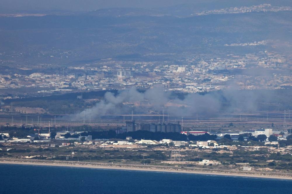 This picture taken from the northern Israeli port city of Haifa shows smoke billowing near the northern Israeli city of Tamra from rockets fired from Lebanon, on Saturday. AFP