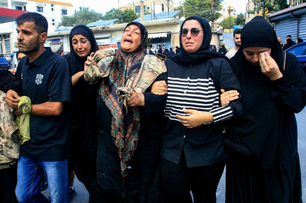 Friends and relatives mourn on Saturday, during the funeral of five people killed in an Israeli airstrike that targeted the southern village of Bazuriyeh a day earlier. 