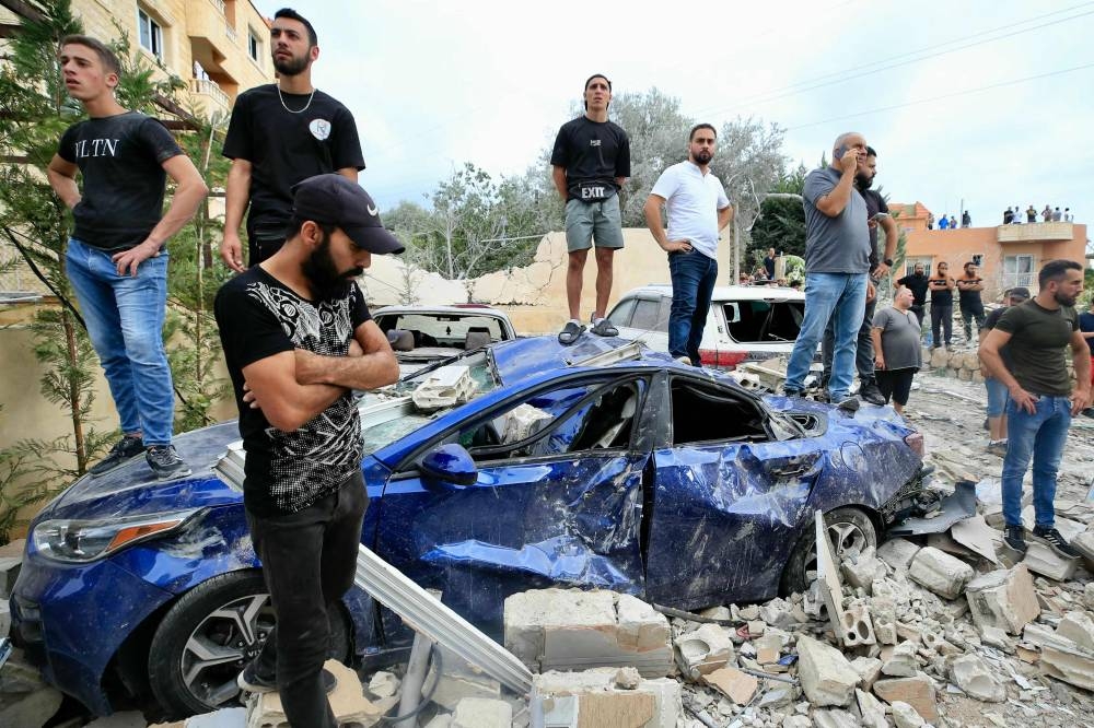 People inspect the damage at the site of an Israeli airstrike that targeted an apartment building in town of Bajra south of Beirut on Saturday. AFP