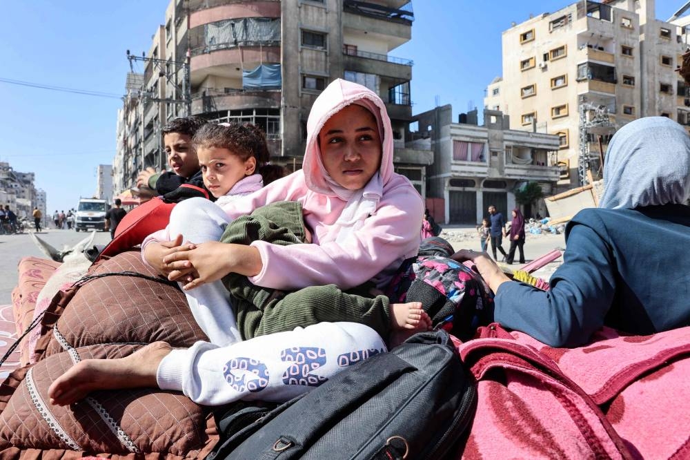 Palestinian children sit atop their family's belongings as they flee areas north of Gaza City in the northern Gaza Strip on Saturday. AFP
