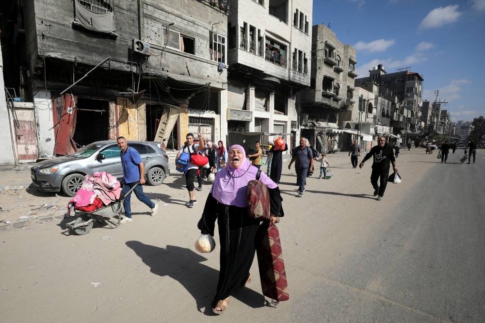 Displaced Palestinians make their way as they flee areas in the northern Gaza Strip in Gaza City on Saturday. REUTERS