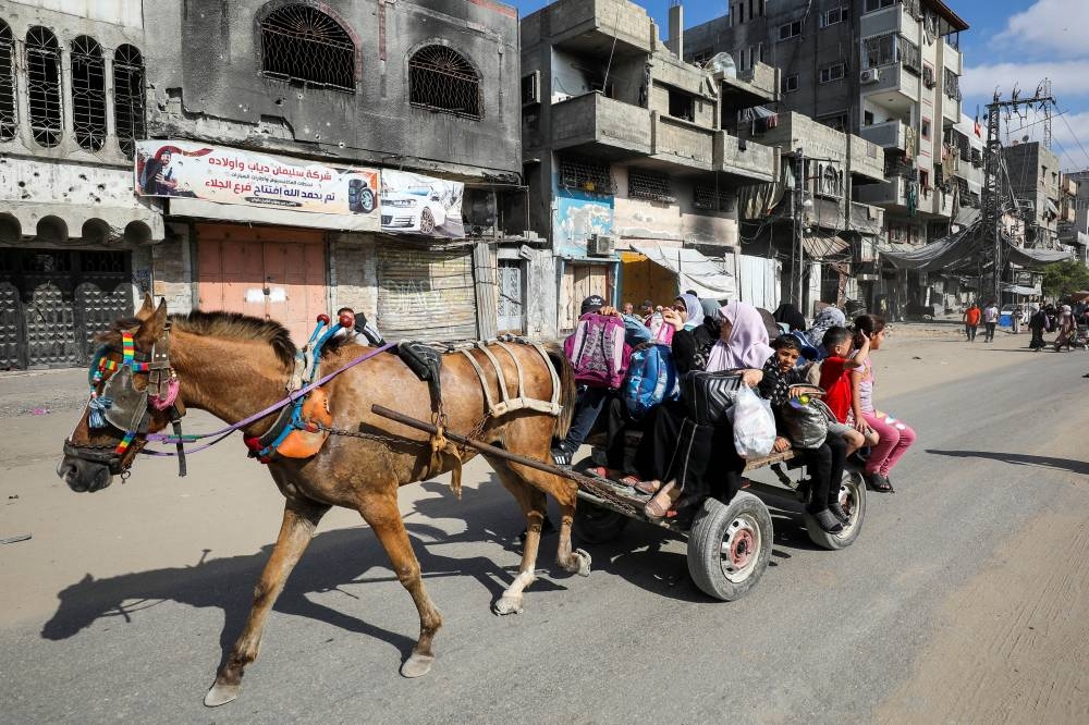 Displaced Palestinians make their way on a cart as they flee areas in the northern Gaza Strip in Gaza City on Saturday. REUTERS