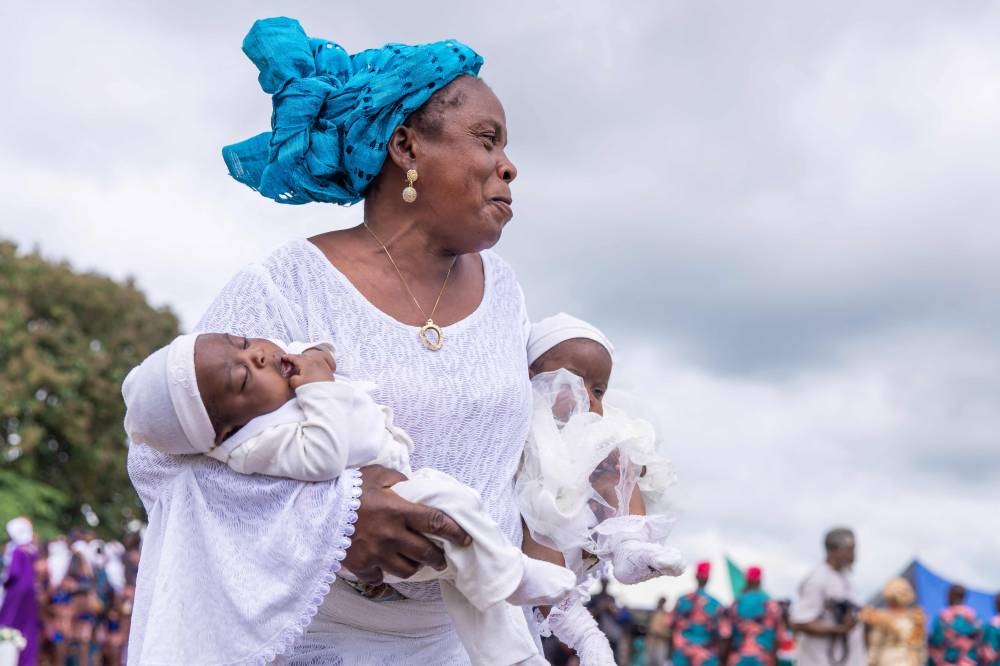 A woman holds twins during the Igboora World Twins Festival 2024, in Igbo-Ora on Saturday. AFP