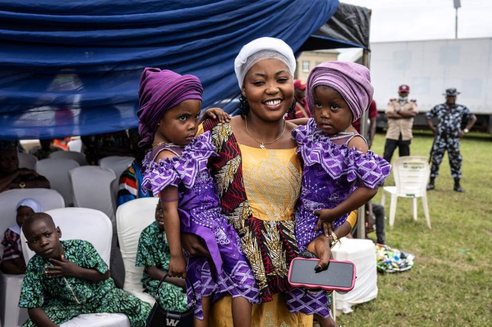 A woman poses with her twins during the Igboora World Twins Festival 2024, in Igbo-Ora on Saturday. AFP