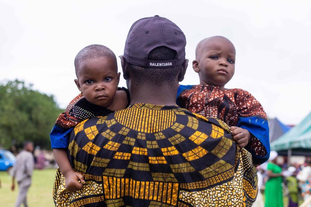 A man holds twins during the Igboora World Twins Festival 2024, in Igbo-Ora on Saturday. AFP