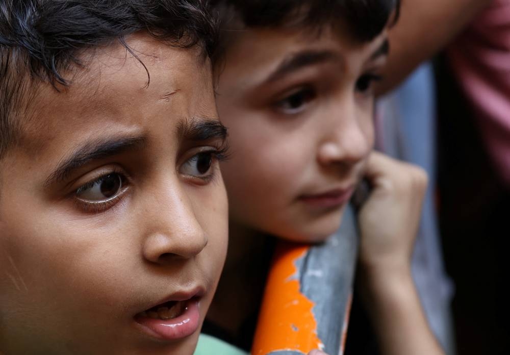 Children living in a shelter for displaced families wait to receive food aid from a local restaurant "Carneo", in Beirut, Lebanon, on Monday. REUTERS