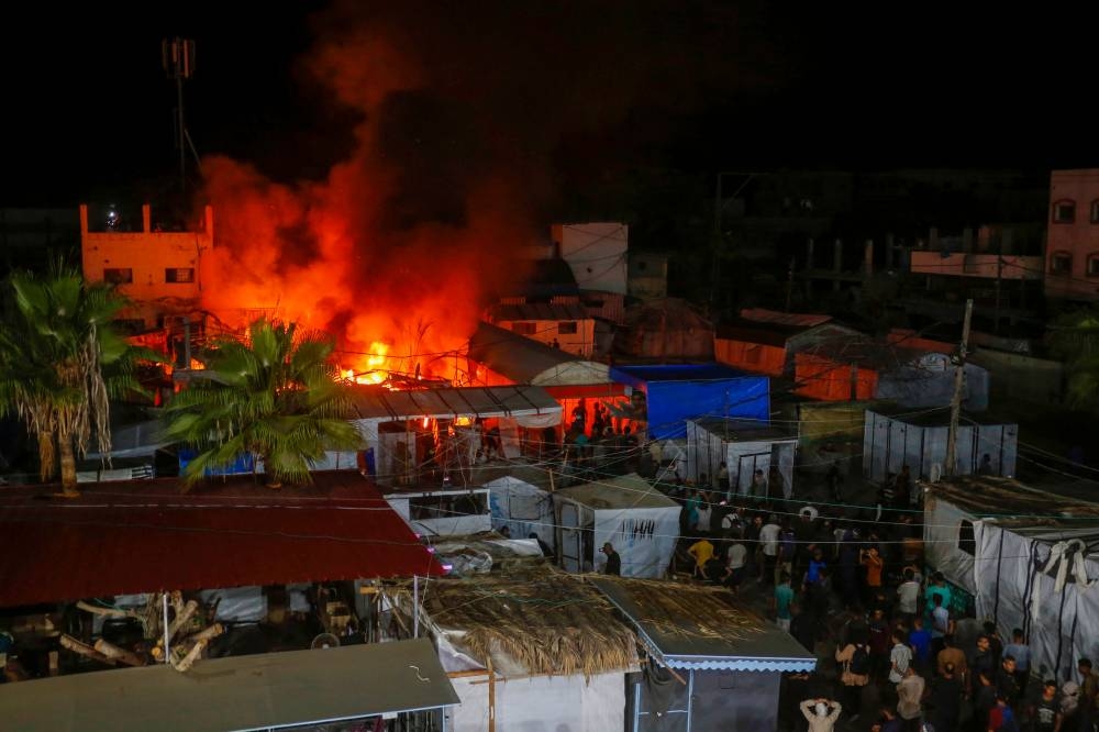 People at the site of an Israeli air strike around tents for displaced people inside the walls of Al-Aqsa Martyrs Hospital in Deir al-Balah, in the central Gaza Strip early on Monday. AFP/UNRWA