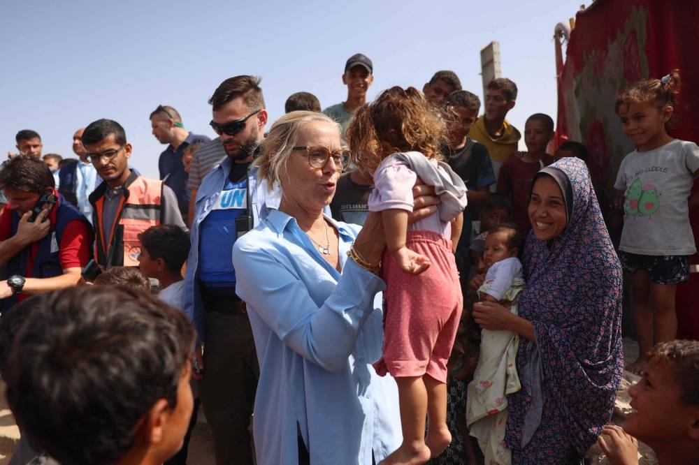 Senior UN Coordinator for Humanitarian Action and Reconstruction in Gaza Sigrid Kaag carries a Palestinian child during her visit to a makeshift camp for displaced Gazans in Mawasi Khan Yunis in the southern Gaza Strip on Tuesday. AFP