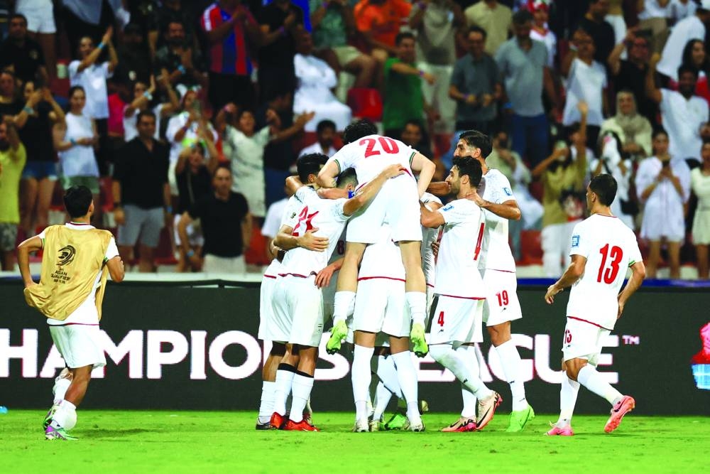 Iran’s Mohammad Mohebbi celebrates scoring their fourth goal with teammates.