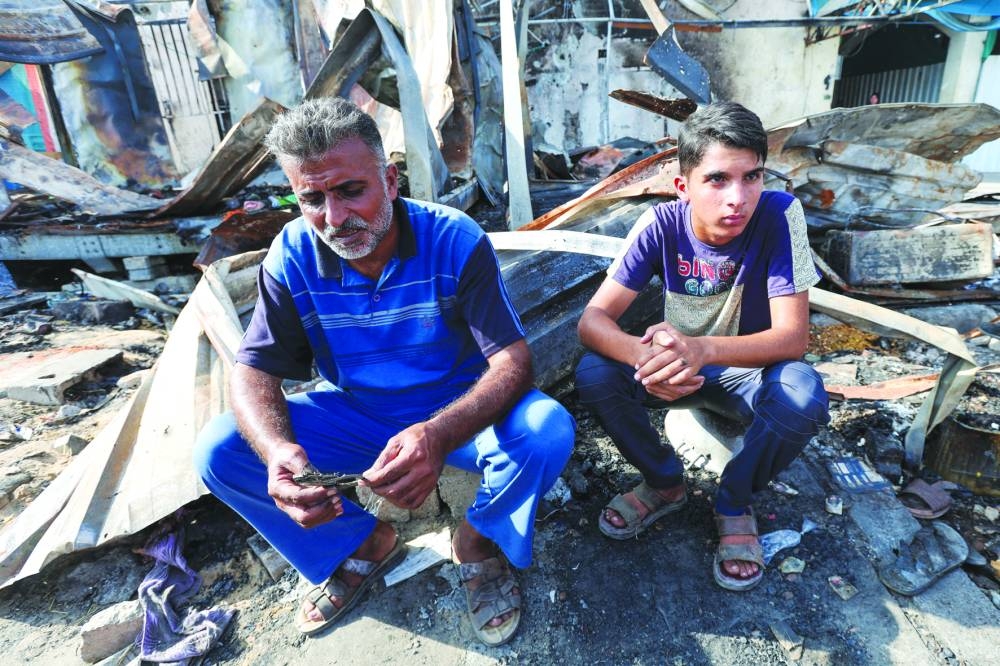 
Mohammed (right), the brother of Palestinian Shaban al-Dalou, who was burnt to death in an Israeli strike on tents sheltering displaced people at Al-Aqsa hospital, looks on at the site of the strike, in Deir Al-Balah in the central Gaza Strip. 