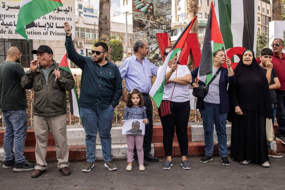A young Palestinian girl holds up a portrait of slain Hamas leader Yahya Sinwar during a rally in Ramallah, in the Occupied-West Bank on Friday. AFP