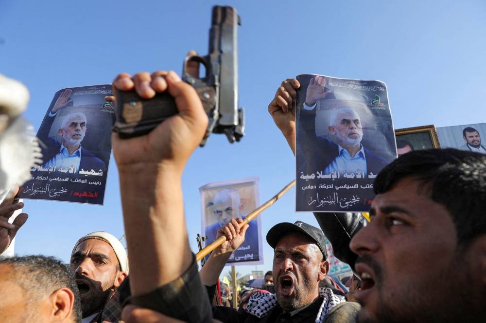 Protesters hold posters showing the late Hamas leader Yahya Sinwar as they rally to show support to Lebanon's Hezbollah and Palestinians in the Gaza Strip, in Sanaa, Yemen on Friday. REUTERS