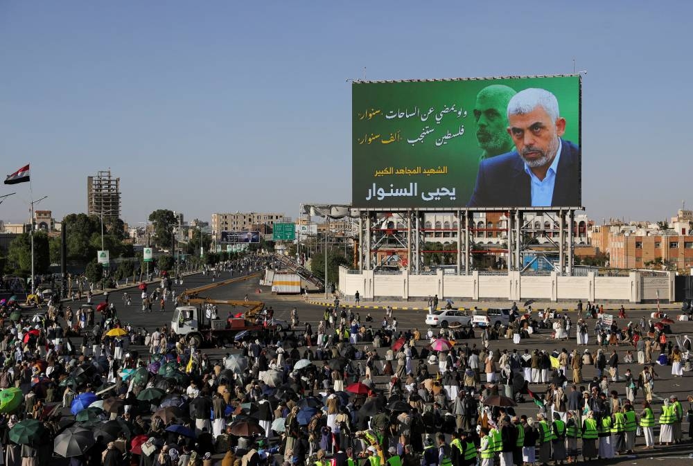 Protesters stand near a billboard showing the late Hamas leader Yahya Sinwar as they rally to show support to Lebanon's Hezbollah and Palestinians in the Gaza Strip, in Sanaa, Yemen on Friday. REUTERS