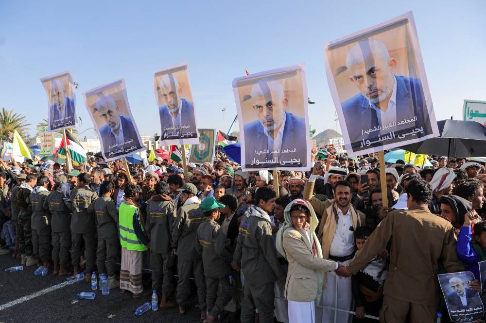 People hold signs showing the late Hamas leader Yahya Sinwar as protesters rally to show support to Lebanon's Hezbollah and Palestinians in the Gaza Strip, in Sanaa, Yemen on Friday. REUTERS