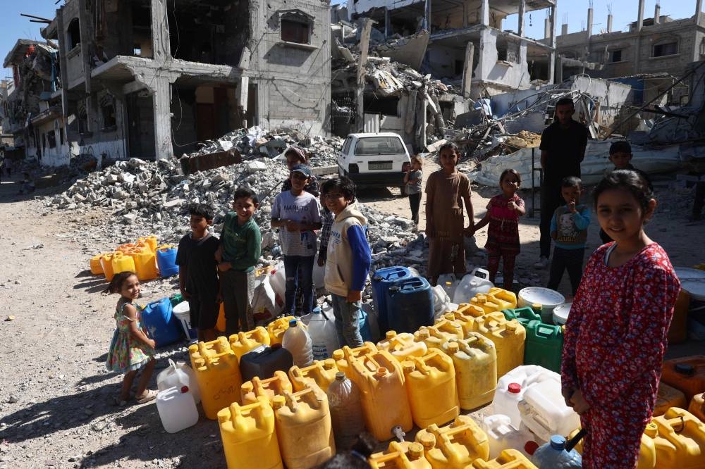 Palestinians queue to fill cans with water near Khan Yunis in the southern Gaza Strip, on Saturday. AFP