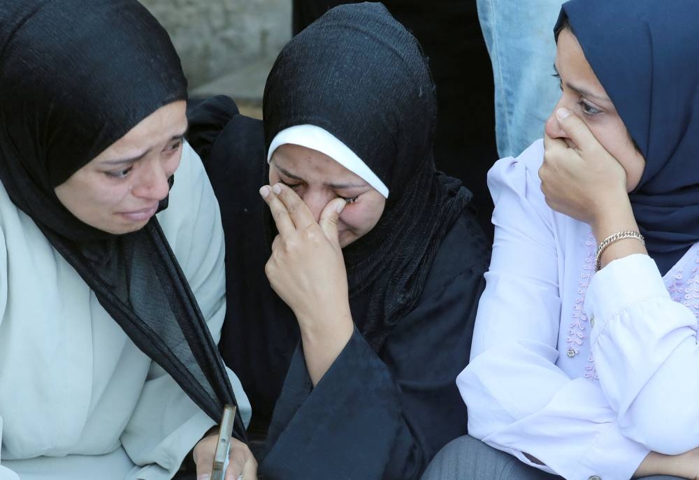Mourners react near the bodies of Palestinians, who were killed in an Israeli strike at Al-Aqsa Martyrs Hospital in Deir Al-Balah in the central Gaza Strip, on Saturday. REUTERS