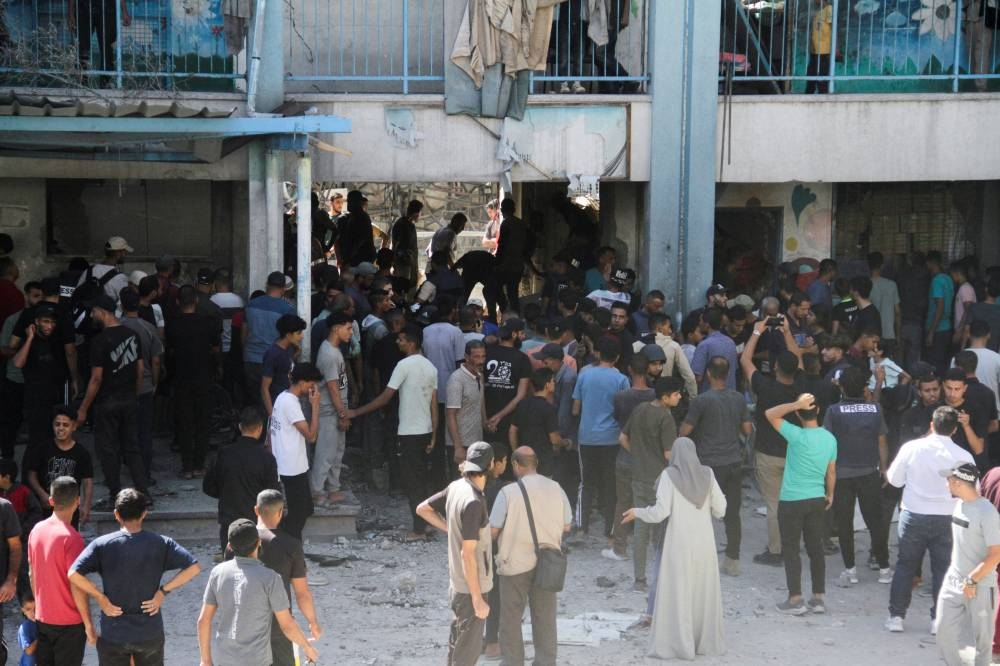 Palestinians inspect the site of an Israeli strike on a school sheltering displaced people at Beach refugee camp in Gaza City, on Saturday. REUTERS