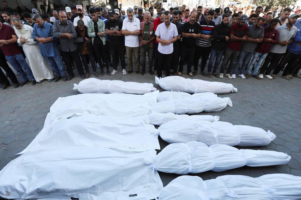 Mourners react near the bodies of Palestinians, who were killed in an Israeli strike at Al-Aqsa Martyrs Hospital in Deir Al-Balah in the central Gaza Strip, on Saturday. REUTERS