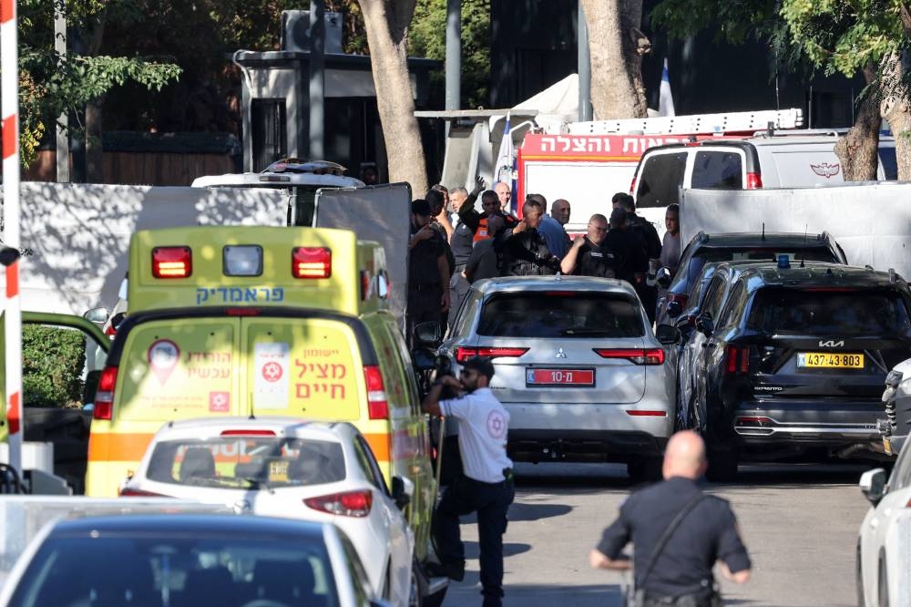 An ambulance can be seen as security forces allow a car to cross a barrier along a street leading to Prime Minister Benjamin Netanyahu's residence in Caesarea on Saturday. AFP