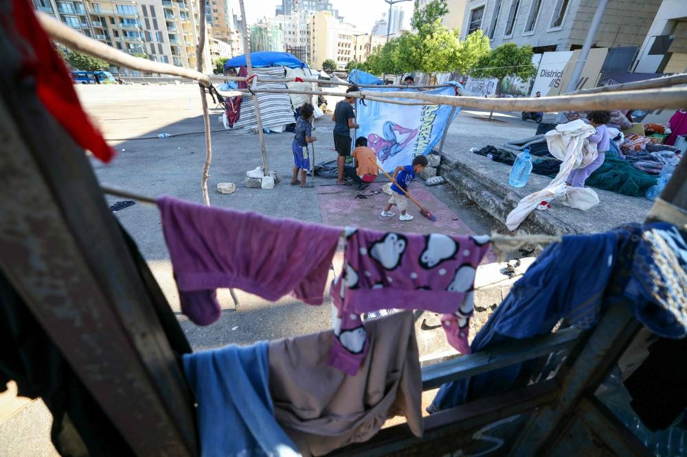 Displaced children stand next to makeshift shelters at a parking lot in downtown Beirut on Saturday. AFP