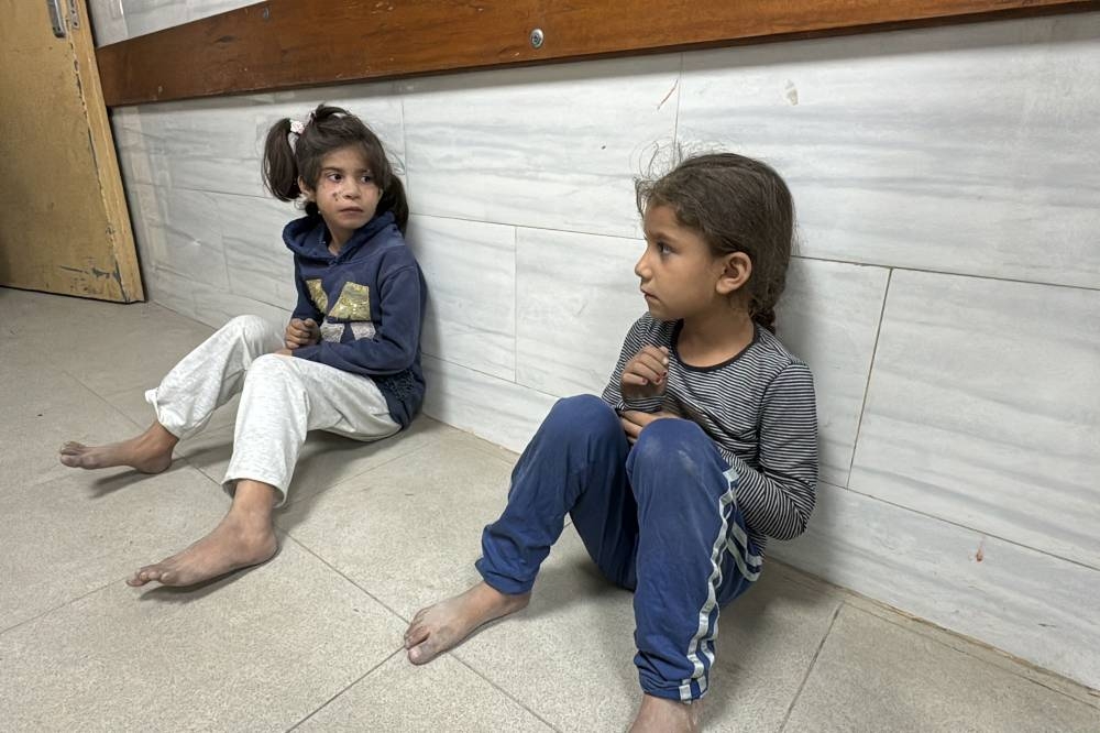 Palestinian children sit in the Kamal Adwan Hospital after an Israeli airstrike in Beit Lahia, in the northern Gaza Strip on Saturday. AFP