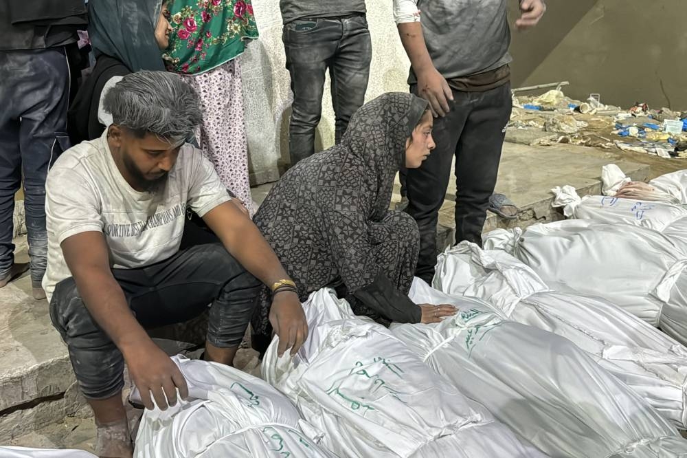 Palestinians mourn over the covered bodies of relatives, killed in an Israeli airstrike, outside the Kamal Adwan Hospital in Beit Lahia, in the northern Gaza Strip on Saturday. AFP